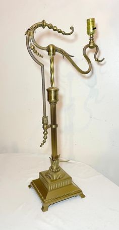 an antique brass table lamp on a white surface