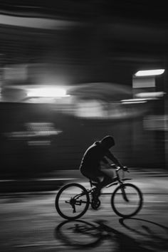 a man riding a bike down a street at night