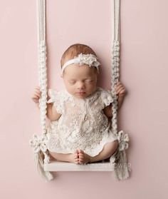 a baby is laying on a swing with her eyes closed and hands behind her head