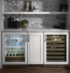 an open refrigerator in a kitchen with white cabinets and marble wallpaper on the walls