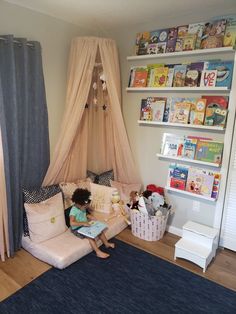 a child sitting on a couch reading a book in a room with bookshelves