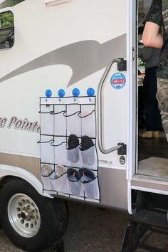 a man standing in front of a white trailer with shoes hanging from it's side