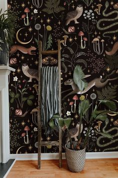 a room with a ladder, plant and wallpaper on the walls that has animals in it