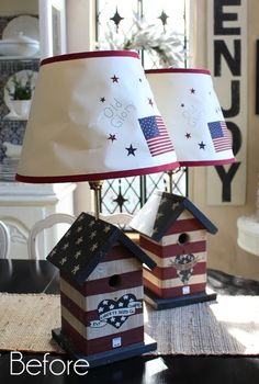 two patriotic birdhouses on a table with a lamp shade