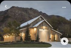 an image of a house with lights on in the front yard and mountains behind it