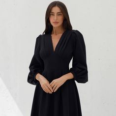 This elegant black midi dress combines timeless style with modern sophistication, making it a versatile choice for any special occasion. The dress features a flattering V-neckline with pleated detailing, voluminous puff sleeves, and a fitted waist, creating a classic yet contemporary silhouette. Made from premium dense crepe fabric, it offers both comfort and a luxurious feel. Whether you're attending a formal event, an evening party, or a sophisticated dinner, this dress will ensure you stand out with elegance and grace.  Elegant black midi dress with V-neckline and pleated bodice details. Features long puff sleeves for a refined, fashion-forward look. Crafted from premium crepe fabric, ensuring durability and comfort. Fitted waistline that accentuates your figure and creates a flattering Refined Fashion, Dress With Puff Sleeves, Classic Black Dress, Elegant Dinner, Pleated Bodice, Black Midi, Long Puff Sleeves, Crepe Fabric, Black Midi Dress