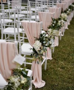 rows of white chairs with pink sashes and flowers on the back, along with greenery