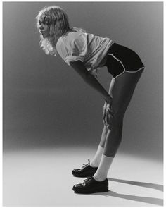 black and white photograph of a woman with her hands on her hips, leaning forward