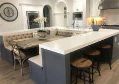 a large kitchen island with stools in the middle and an oven on the other side