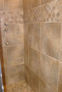 a tiled shower stall in a bathroom with tile flooring and wall tiles on the walls