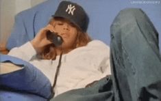 a woman laying in bed while talking on a cell phone