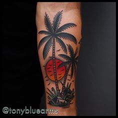 a man's arm with a palm tree and sunset tattoo on the left forearm