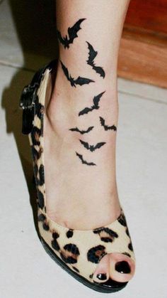 a woman's foot with bats on it and the caption reads, tattoo by tom raven