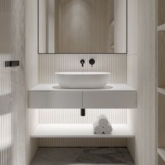 a white sink sitting under a bathroom mirror next to a wooden shelf filled with towels