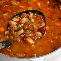 a spoon full of beans and sausage soup