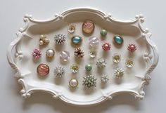 a white tray filled with lots of different types of earrings