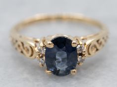 "This sapphire ring has a beautiful style to it! Swirling gold filigree and a curving silhouette lead the eye to the deep, vibrant blue sapphire at the center. Twinkling diamonds balance the design nicely. Metal: 14K Yellow Gold Gem: Sapphire .80 Carats Gem Measurements: 6.7 x 5.0 mm, Oval Accents: 4 Diamonds totaling .08 Carats, SI in Clarity, G in Color Ring Size: 4.25 Marks: \"ROR15 14K\" Stamped on the inside band To view a video of this piece check out the link below: https://vimeo.com/7734 Rose Gold Halo Ring, Diamond Sapphire Engagement Ring, Diamond Gold Ring, Sapphire Diamond Engagement, Sapphire Solitaire Ring, Right Hand Ring, Floral Engagement Ring, Ring Sapphire, White Gold Sapphire