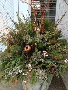 a planter filled with lots of greenery next to a white door and window