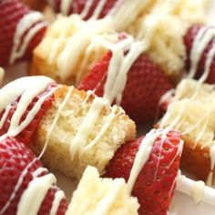 strawberry shortcakes with white glaze drizzled over them on a plate