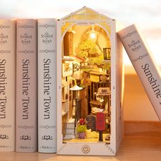 there are three books that have been placed next to each other on a table with a doll house in it