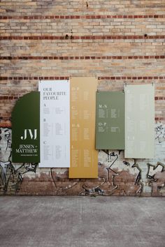 three different colored posters on the side of a brick wall