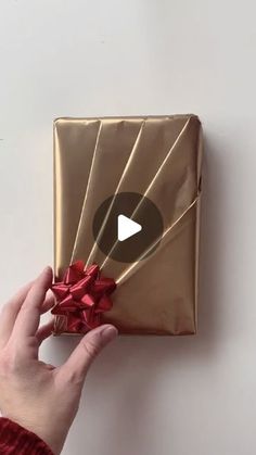 a person holding a wrapped present in their hand