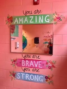 a mirror with some writing on it in the wall next to a pink brick wall that says you are amazing, you are brave, you are strong, strong, strong and strong