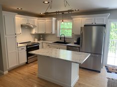 a kitchen with white cabinets and stainless steel appliances