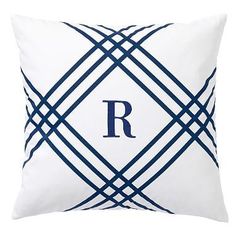 a white and blue pillow with lines on the front, along with dark blue piping