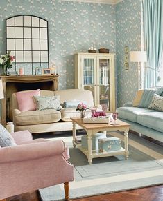 the living room is decorated in pastel blue and pink tones with floral wallpaper