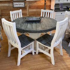 a kitchen table with four chairs around it in front of a wall that has wood planks