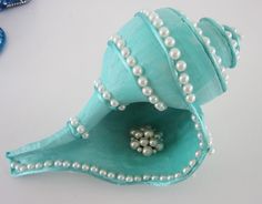 a blue vase with pearls and beads on it