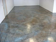 an empty room with concrete floors and white walls