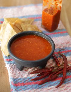 a bowl of chili sauce next to some tortilla chips