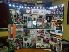 a bulletin board with pictures and lights on the wall in front of a table top