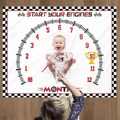 a woman holding up a baby in front of a clock with the words start your engines on it