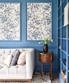 a living room with blue painted walls and furniture in the corner, including a white couch