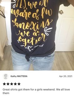 a person taking a selfie in the mirror wearing a t - shirt with writing on it