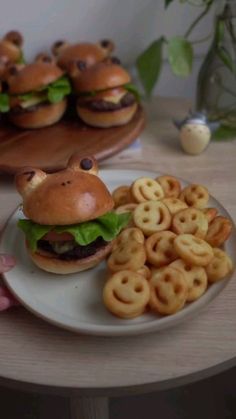 there is a plate with some hamburgers and pretzels on the table next to it