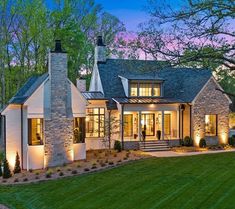 a house that is lit up at night with lights on the front and side windows