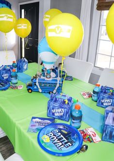 the table is set up with balloons, water bottles and other items for a birthday party