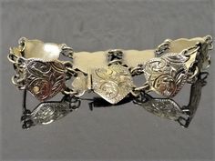 "Beautiful vintage heart bracelet with lovely etched design. Gold over sterling silver. Faintly marked .925 on clasp. Links measure 1/2\" Bracelet measures 6 1/2\" Weighs 13.9 grams All items are gift boxed ready for giving. If sending directly to someone as a gift I am happy to enclose a card with your personal message at no additional cost. I have many beautiful period antique pieces in my shop. Please consider browsing and don't hesitate to contact me if you have any questions or would like f Vintage Adjustable Charm Bracelet For Formal Occasions, Adjustable Vintage Charm Bracelet For Formal Occasions, Antique Sterling Silver Bracelet Nickel-free Gift, Ornate Stamped Bracelets For Gift, Vintage Heart Bracelets For Formal Occasions, Silver Engraved Heart Bracelet, Adjustable, Heart-shaped Engraved Bracelets For Formal Occasions, Sterling Silver Engraved Heart Bracelet, Heart Shaped Engraved Bracelets For Formal Occasions