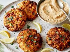 three crab cakes on a plate with dipping sauce