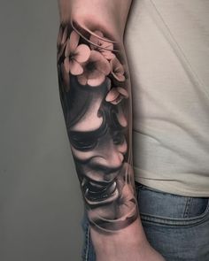 a person with a tattoo on their arm holding a cup and flower in the other hand