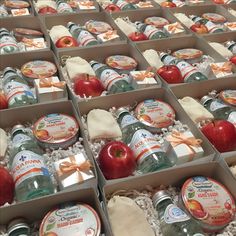 several boxes filled with apples and cheeses on display in an open box, some wrapped in white paper