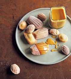 a plate topped with donuts covered in icing next to a jar of peanut butter