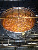 a pot filled with beans cooking on top of an open oven door next to the words hearty ranch style baked beans