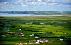 an aerial view of green fields and water