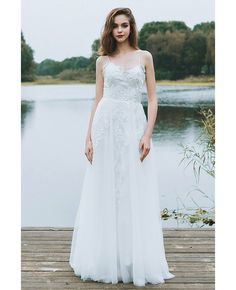 a woman in a white dress standing on a dock