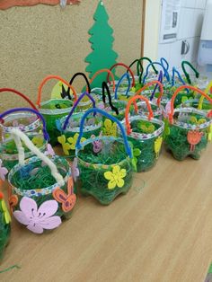 there are many plastic baskets with flowers in them on the table next to each other